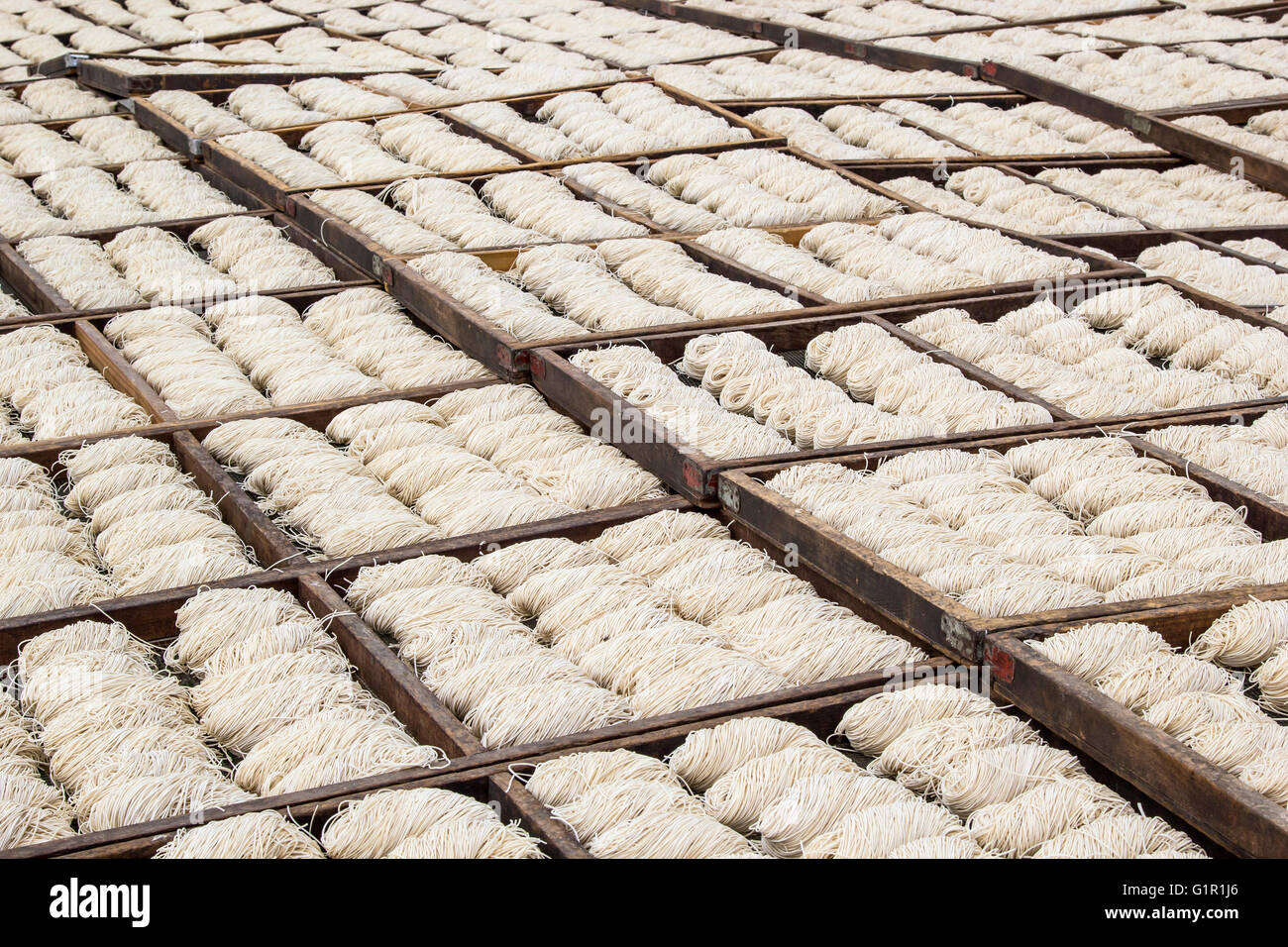 Viele chinesische Nudeln Trocknen unter der Sonne in Holztabletts Stockfoto