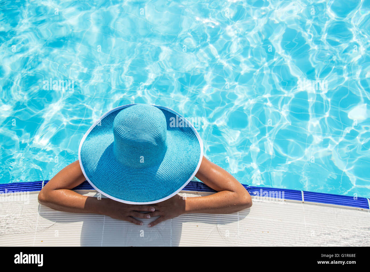 Frau in Sonnenhut im Schwimmbad. Ansicht von oben. Stockfoto