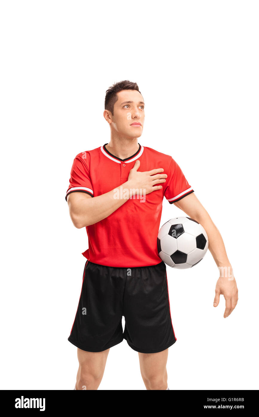 Vertikale Schuss eines jungen Fußballspielers hören auf die Clubhymne isoliert auf weißem Hintergrund Stockfoto
