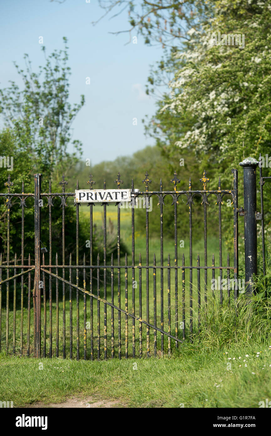 Schmiedeeiserne Tore mit einem privaten Zeichen. Oxfordshire, England Stockfoto