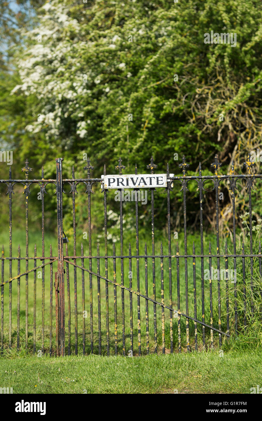 Schmiedeeiserne Tore mit einem privaten Zeichen. Oxfordshire, England Stockfoto