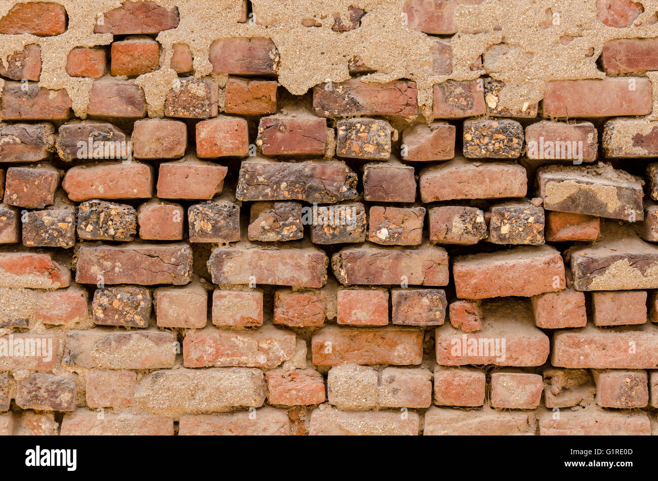 Unregelmäßig geformte verwitterten roten Stein Mauer. Stockfoto