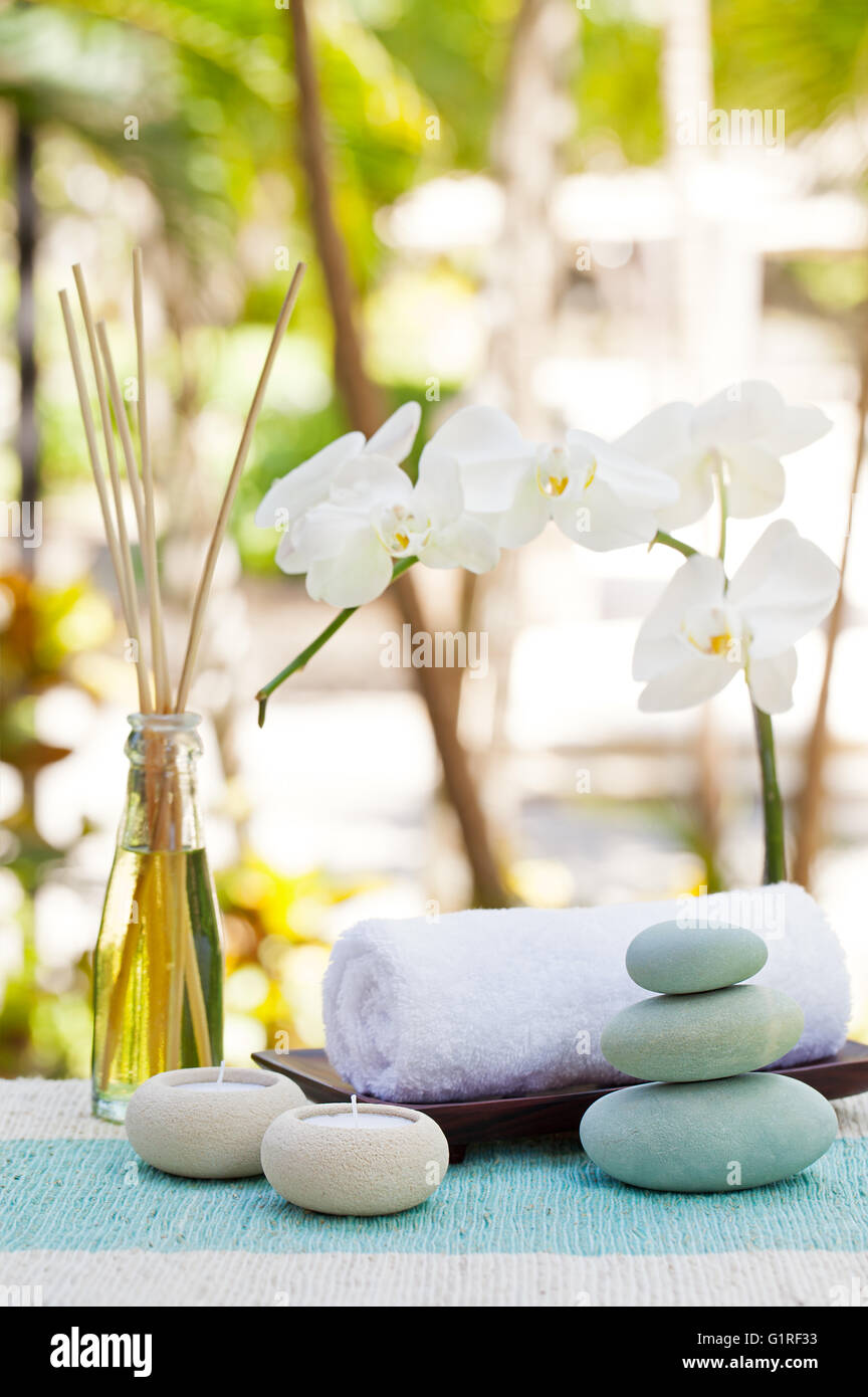 Spa und Wellness massage Einstellung Stillleben mit Kerze, Handtuch und Steinen Outdoor-Sommer-Hintergrund Stockfoto