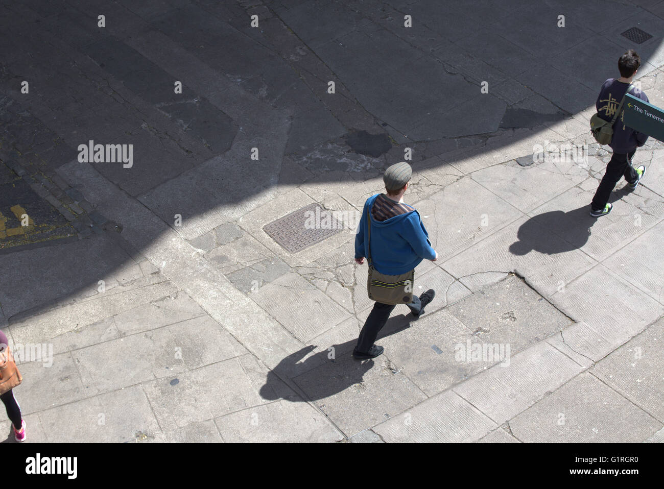 Junger Mann mit Schatten gesehen von oben, Glasgow, Schottland, Großbritannien Stockfoto