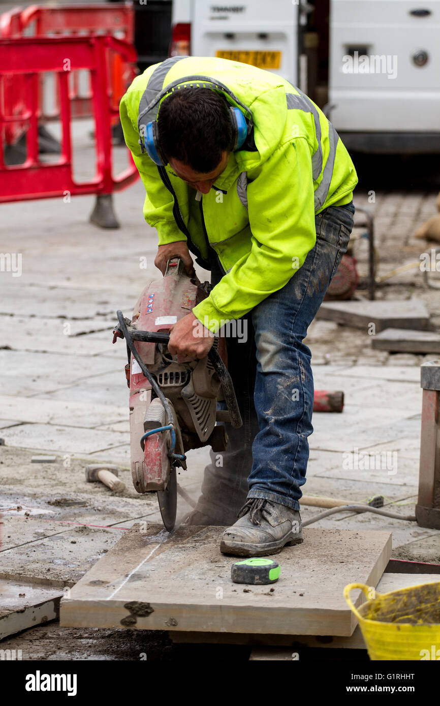 Arbeiter aus den hoch-und Tiefbau-Unternehmen "Land & Gebäudetechnik" schneiden und Verlegung von Betonplatten in Dundee, Großbritannien Stockfoto