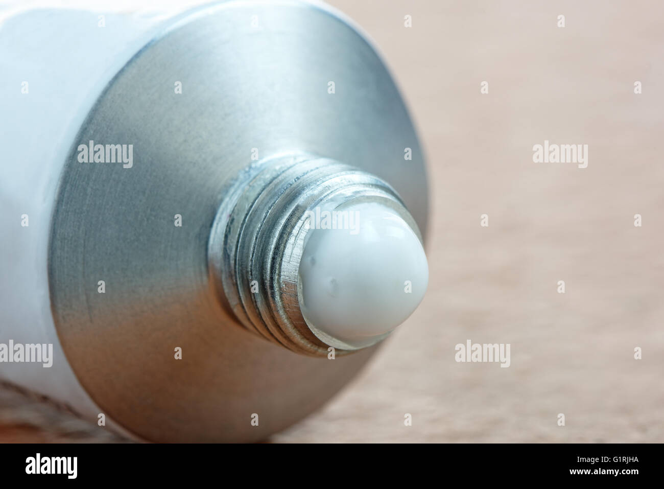 Eine Tube generische Salbe oder Creme mit einem Tropfen herausdrücken Stockfoto