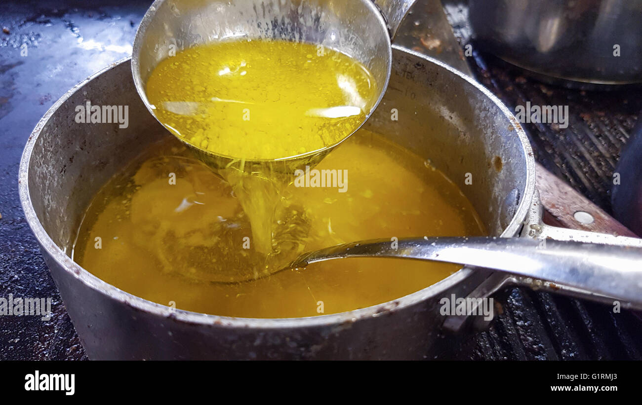 Gießen gelb, zerlassene, geklärte Butter, wieder nach unten in die Casserol bei einer Restaurantküche Stockfoto