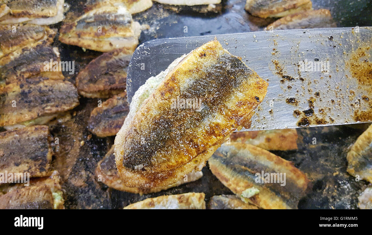 Fried zerschlagen Ostseehering, auf einem Spatel, infront von mehr zerschlagen Heringe Stockfoto