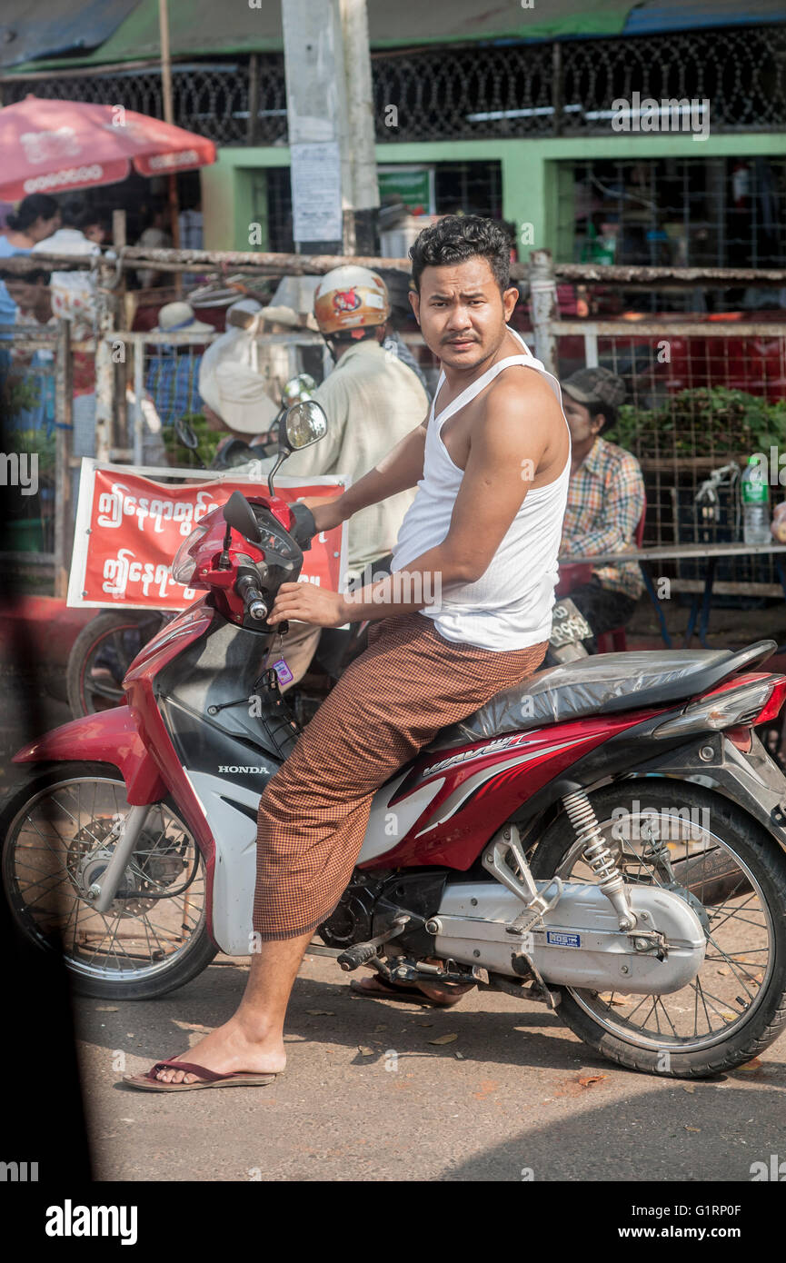 Ein Mann im weißen Hemd und brauner Rock mit dem Motorrad in eine Kamera schaut. Stockfoto