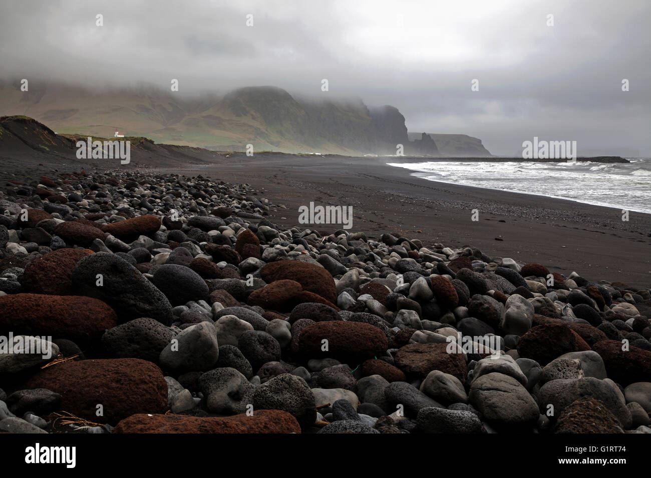 Strand mit vulkanischen Felsen und bedecktem Himmel, Vik, Island Stockfoto