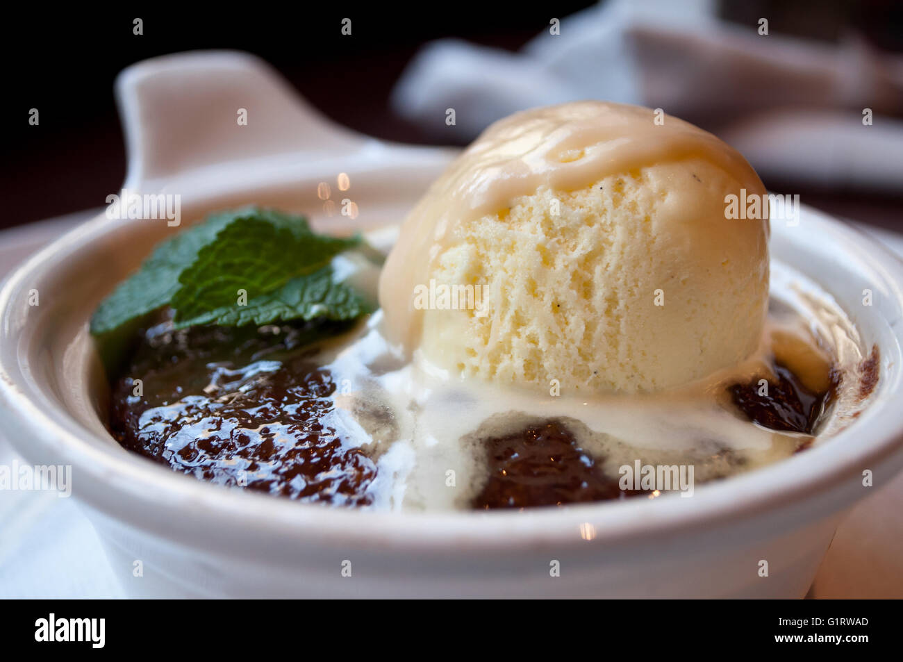 Eine Schokolade "Lava-Kuchen" sickert Milchbonbons als Vanille Eis schmilzt an der Spitze. Stockfoto