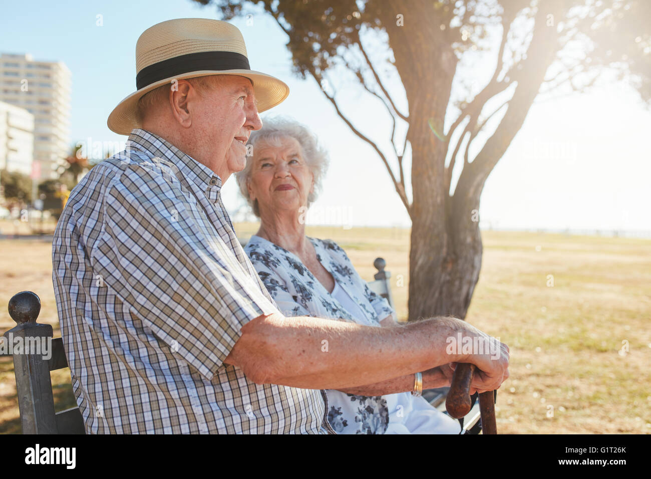Richtungskontrolle Ansicht der ältere Mann und Frau sitzen auf einer Bank im Freien. Älteres Paar auf einer Parkbank sitzen. Stockfoto