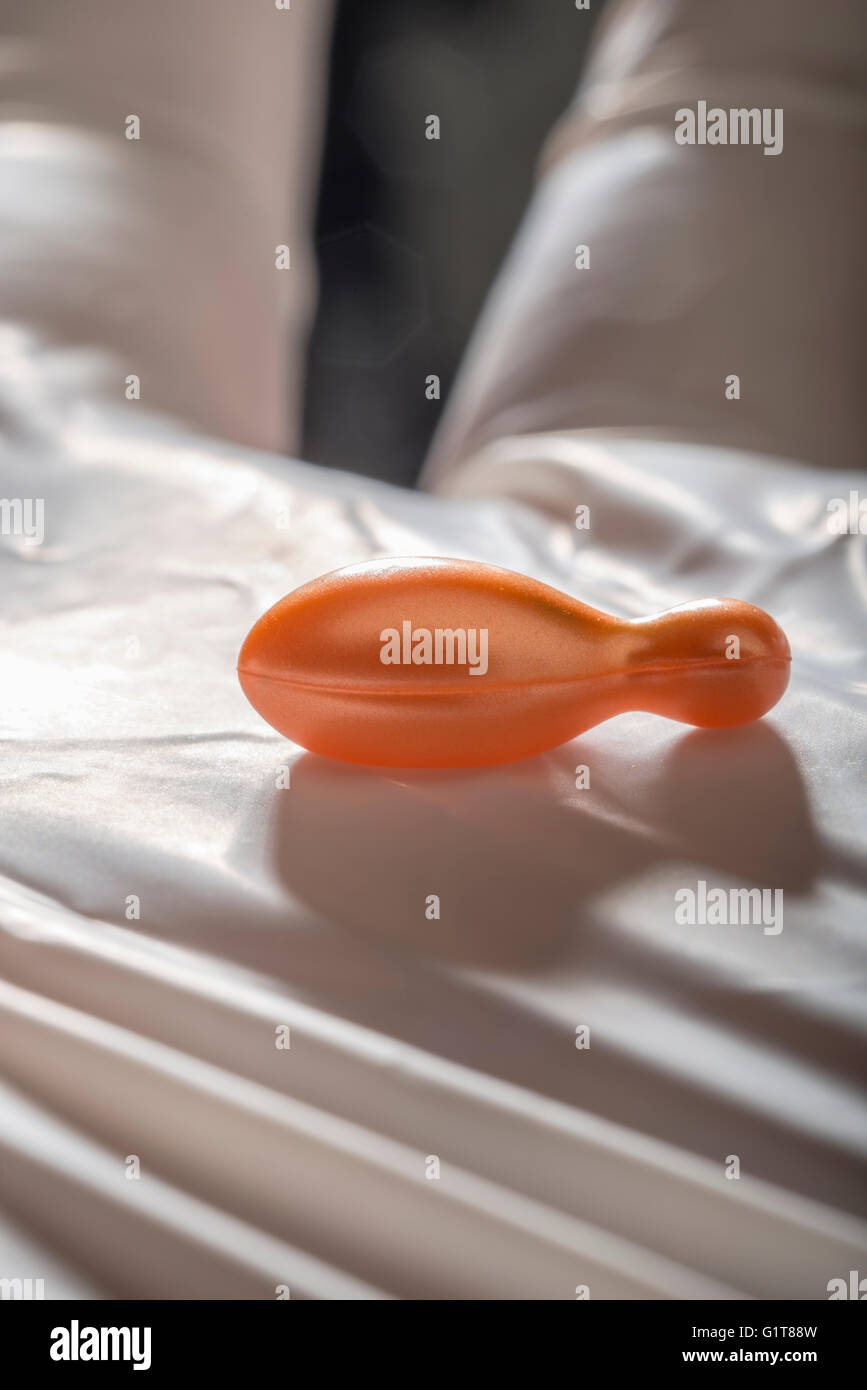 Hand mit Handschuh hält Gel Kapseln Stockfoto