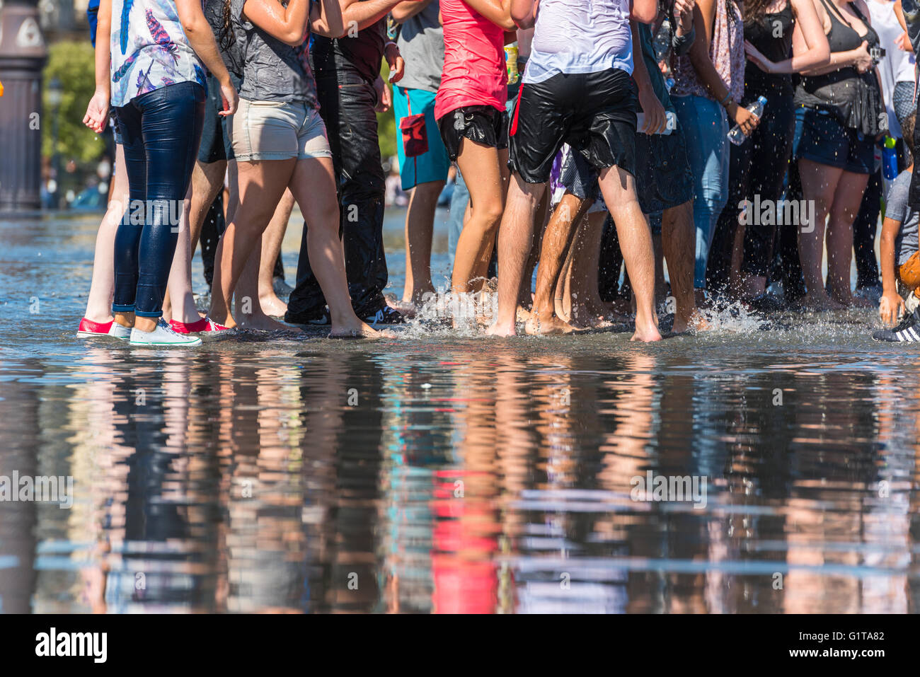 Leute, die Spaß in einem Spiegel-Brunnen vor dem Place De La Bourse in Bordeaux, Frankreich Stockfoto
