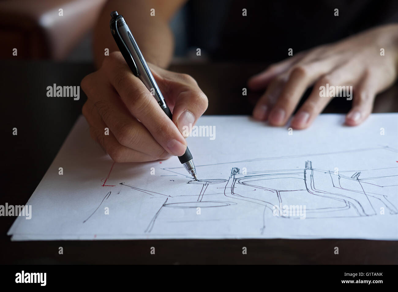 Hand des Designers mit seinem Stift entwerfen und skizzieren seine Idee auf Skizzenbuch Stockfoto