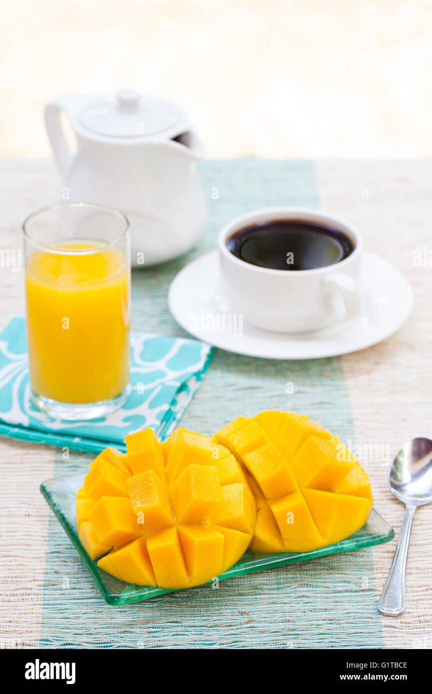 Gesundes Frühstück frische tropische Früchte Mango und Orangensaft, Kaffee Stockfoto