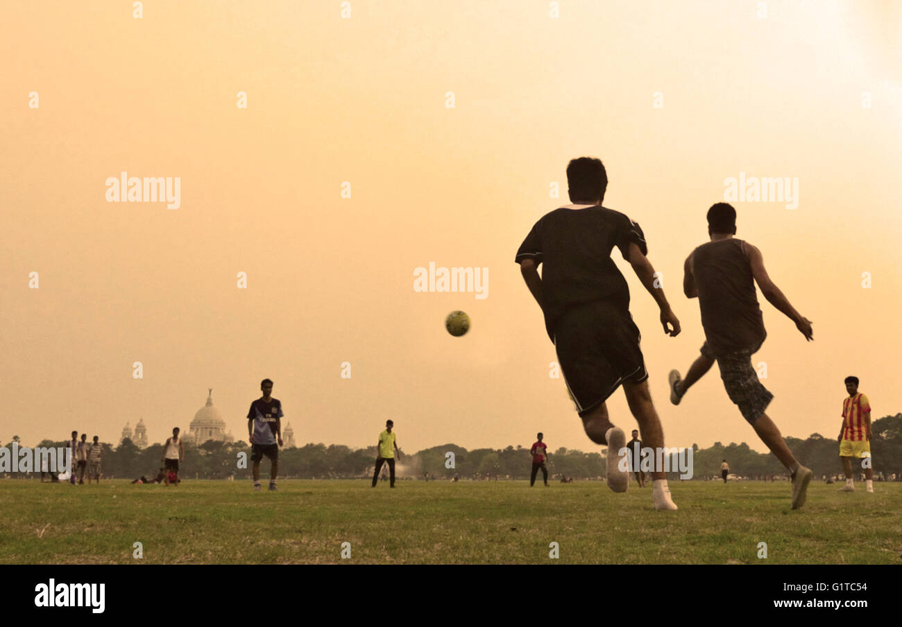 Fußballspielen in Maidan Bereich mit Victoria Memorial im Hintergrund, Kolkata, Westbengalen, Indien Stockfoto