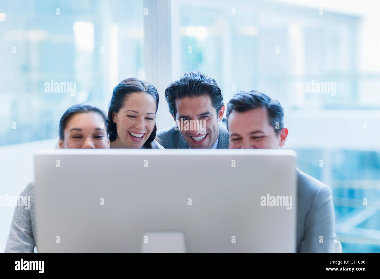 Lachende Geschäftsleute arbeiten am Computer im Büro Stockfoto
