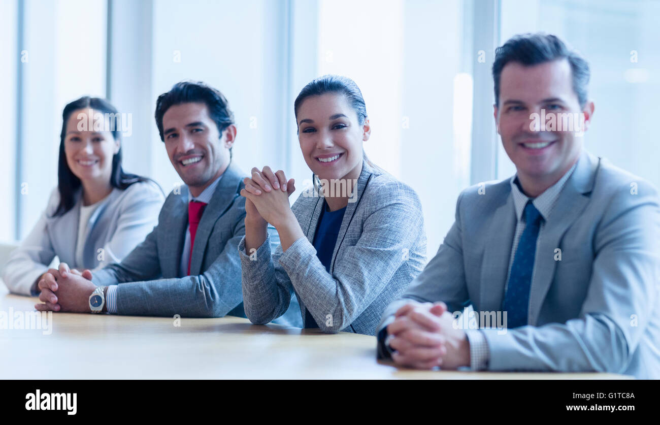 Porträt des Lächelns Geschäftsleute sitzen in einer Reihe im Konferenzraum Stockfoto