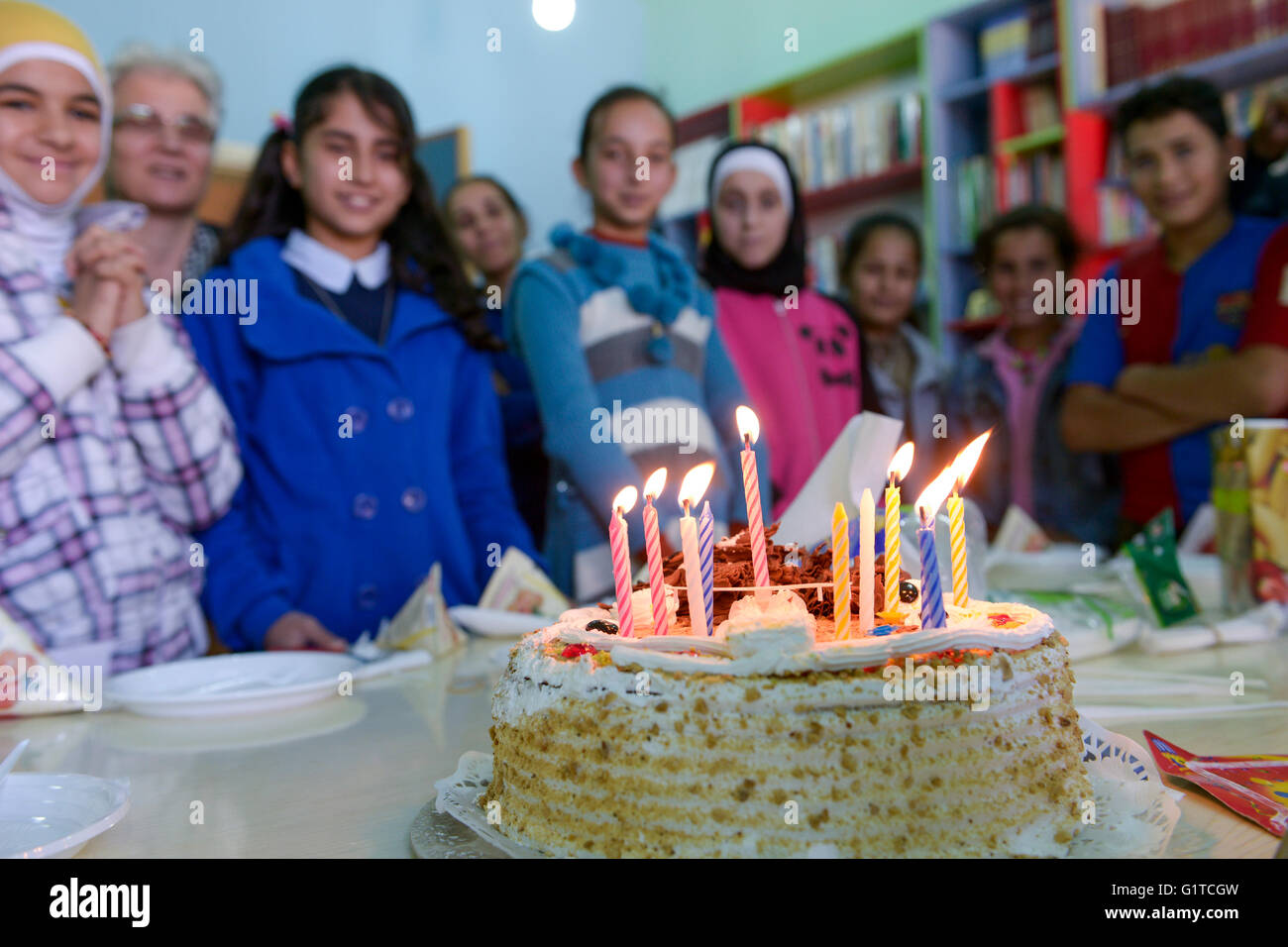 Libanon Deir el Ahmad, einem maronitischen christlichen Dorf im Beqaa Tal, Schule für syrische Flüchtlingskinder, Kinder feiern einen Geburtstag zusammen, Geburtstagskuchen mit Kerze Stockfoto