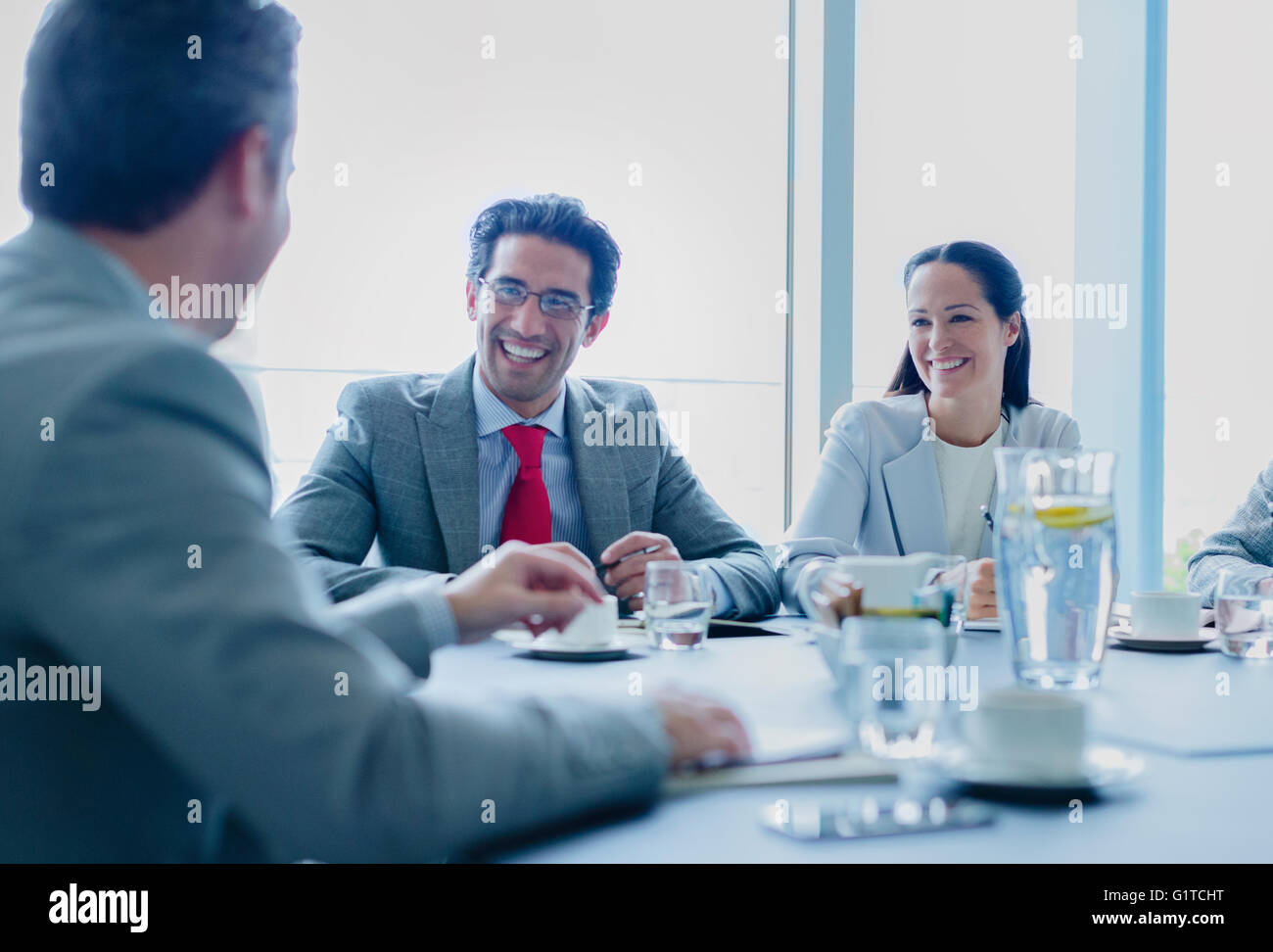 Lächelnde Geschäftsleute sprechen im Konferenzraum Stockfoto