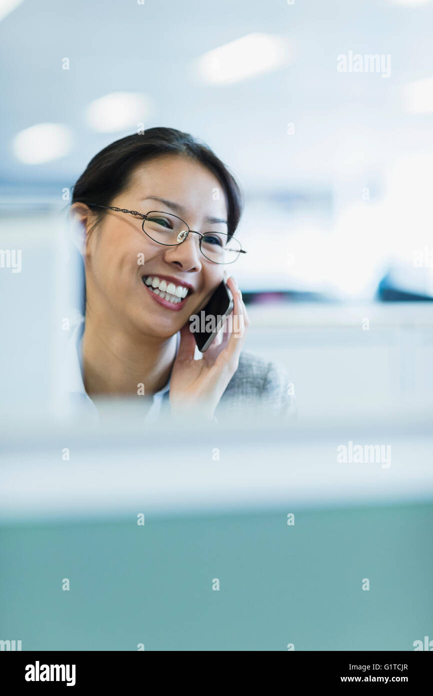 Lächelnde Geschäftsfrau Gespräch am Telefon im Büro Stockfoto