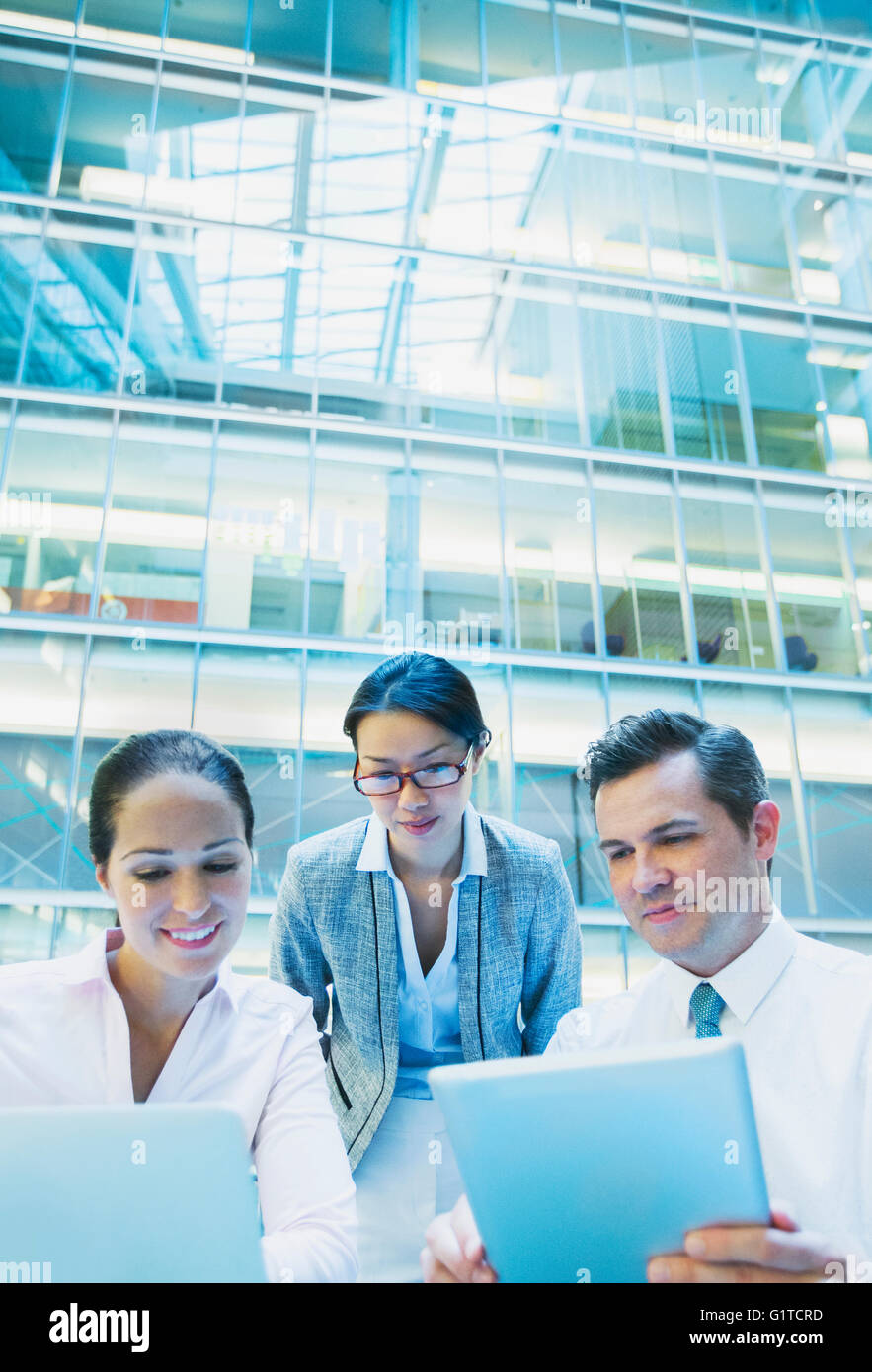 Geschäftsleute, die mit Laptop und digital-Tablette im Büro atrium Stockfoto