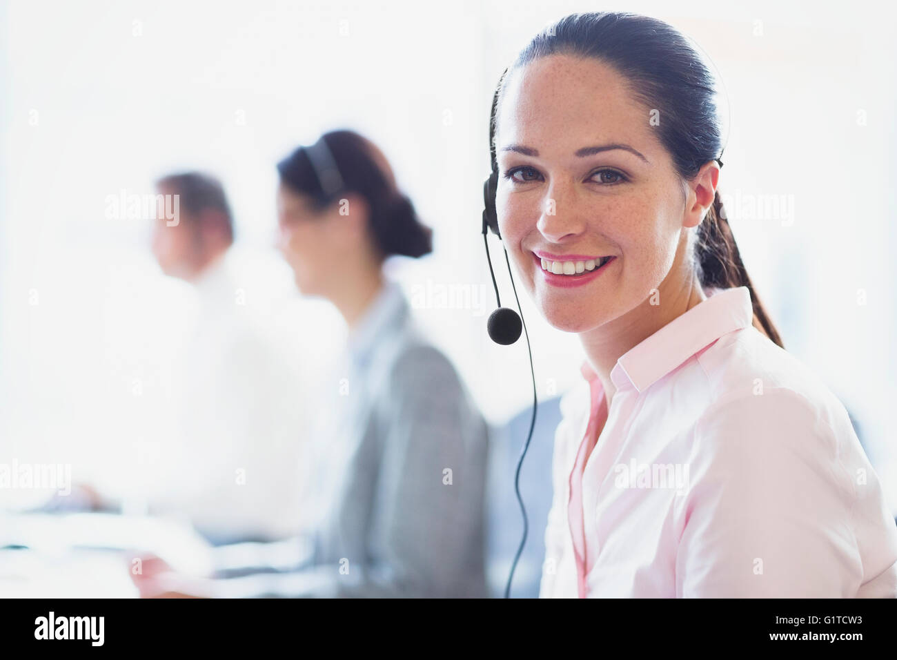 Porträt von lächelnden Geschäftsfrau im Gespräch am Telefon mit Kopfhörer Stockfoto