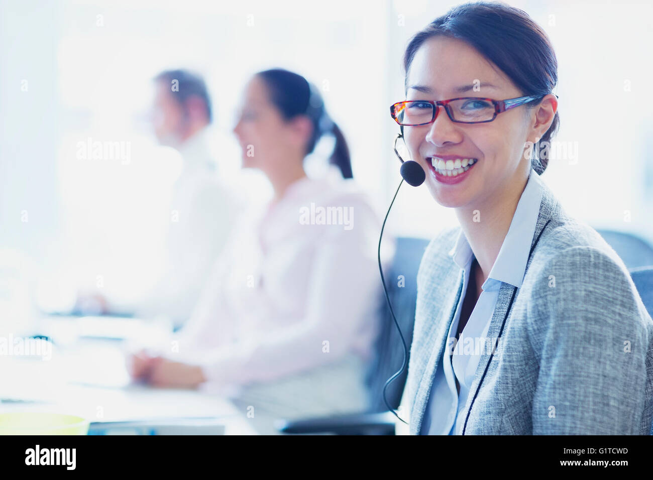 Porträt von lächelnden Geschäftsfrau im Gespräch am Telefon mit Kopfhörer Stockfoto
