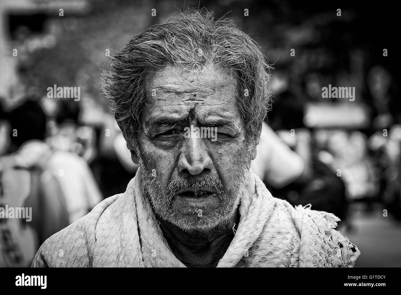 Ein grauhaariger und unrasierter Mann geht durch die Straßen außerhalb der Kapaleeshwarar Tempel, Mylapore, Chennai, Tamil Nadu, Indien Stockfoto