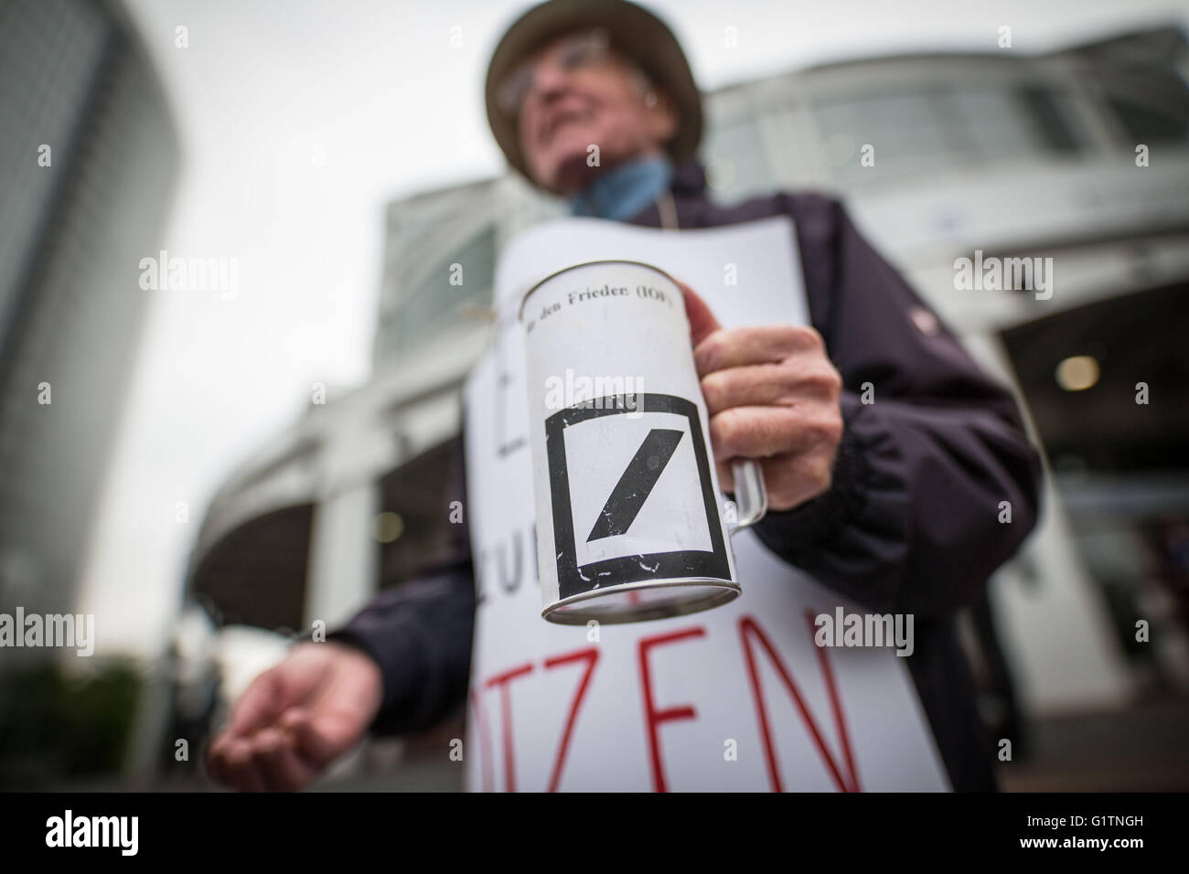 Frankfurt am Main, Deutschland. 19. Mai 2016. Ein Demonstrant hält ein Sammeln von Feld, das das Deutsche Bank Logo am Eingang zur ordentlichen Hauptversammlung der deutschen Finanzdienstleistungs-Unternehmen in Frankfurt Am Main, Deutschland, 19. Mai 2016 verfügt über. Bildnachweis: Dpa picture Alliance/Alamy Live News Stockfoto