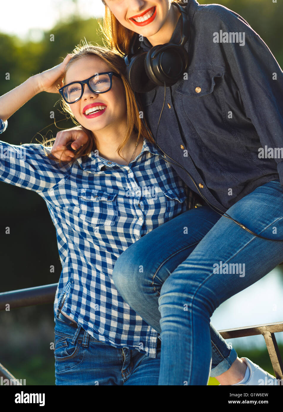 Zwei verspielte junge Frauen, die Spaß im Freien im Abendlicht Stockfoto