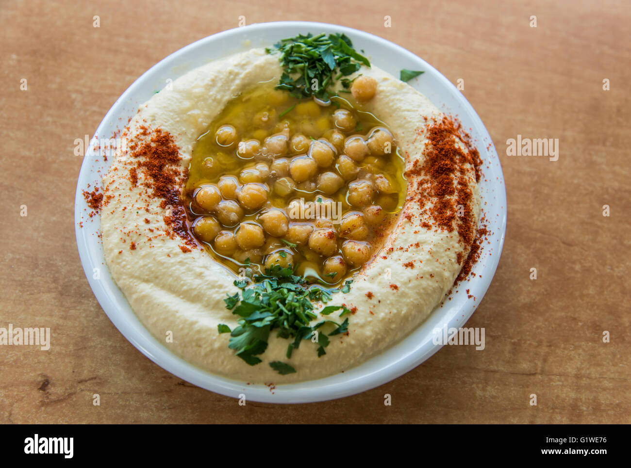 Hummus mit Olivenöl, Petersilie und Bohnen Stockfoto