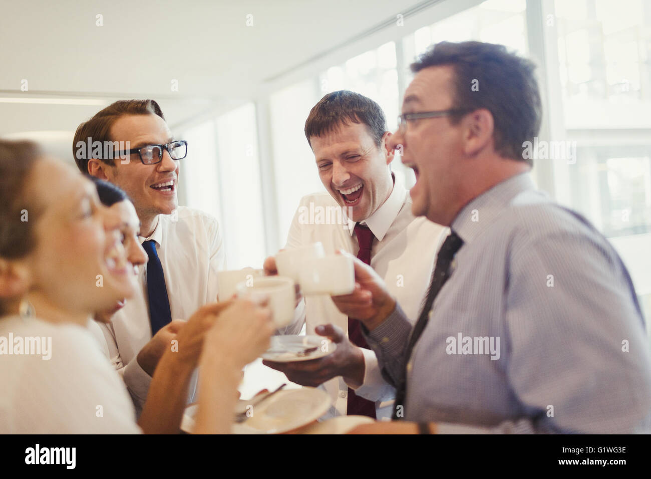 Business-Leute lachen und trinken Kaffee im Büro Stockfoto