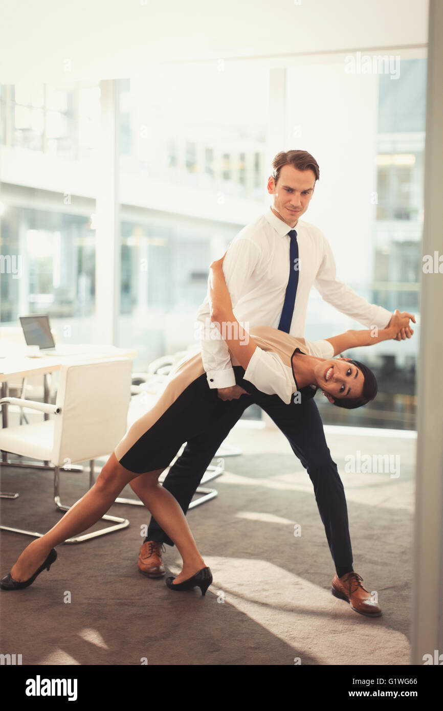 Porträt von Unternehmer und Unternehmerin, die Tango tanzen, im Konferenzraum Stockfoto