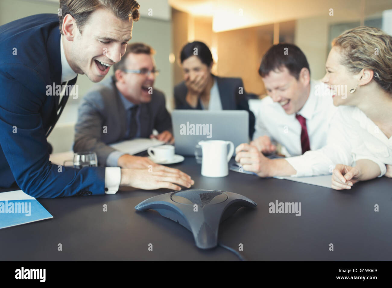 Lachend Geschäftsleute auf Telefonkonferenz im Konferenzraum Stockfoto