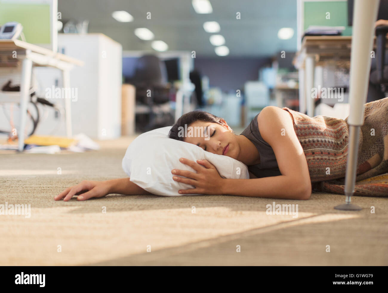 Geschäftsfrau mit Kissen auf Büroetage zu schlafen Stockfoto