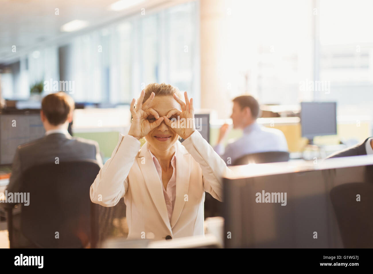Porträt von verspielten Geschäftsfrau, die vorgibt, am Schreibtisch im Büro eine Brille tragen Stockfoto