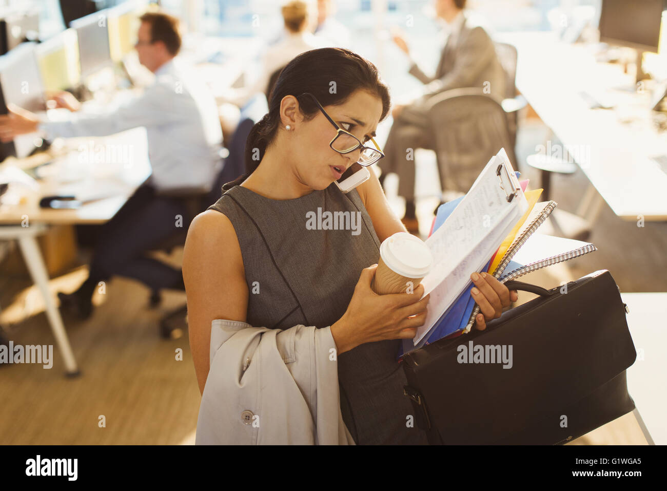 Betonte Geschäftsfrau, die kämpfen, um Multitasking im Büro Stockfoto