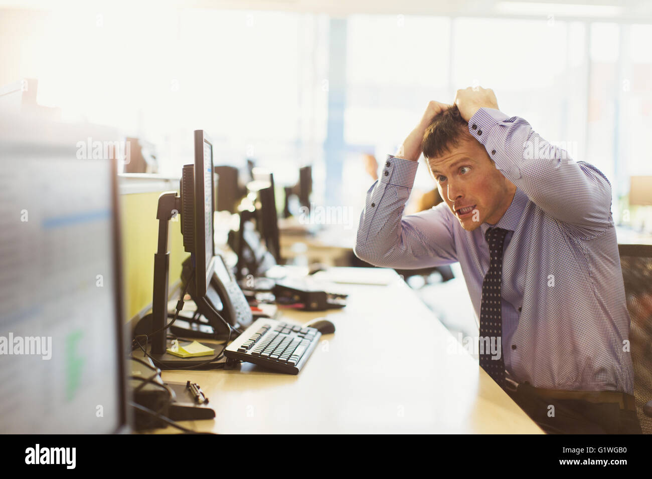 Betonte Geschäftsmann seine Haare herausziehen am Computer im Büro Stockfoto