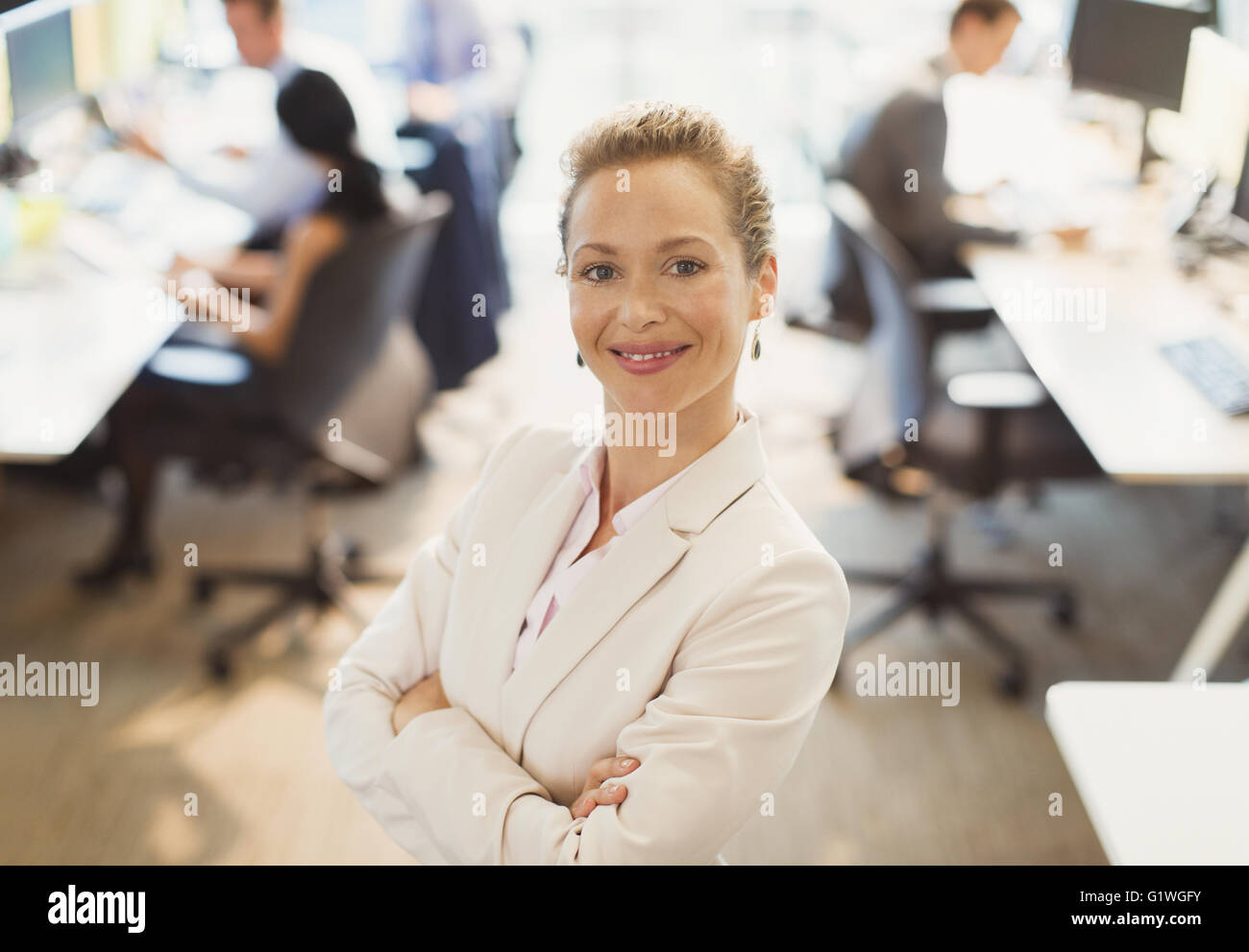 Porträt von zuversichtlich Geschäftsfrau mit verschränkten im Büro Stockfoto