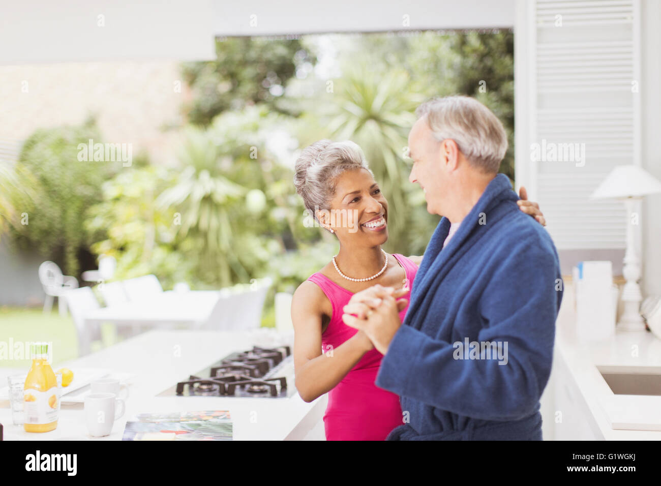 Lächelnd älteres paar tanzen in Küche Stockfoto
