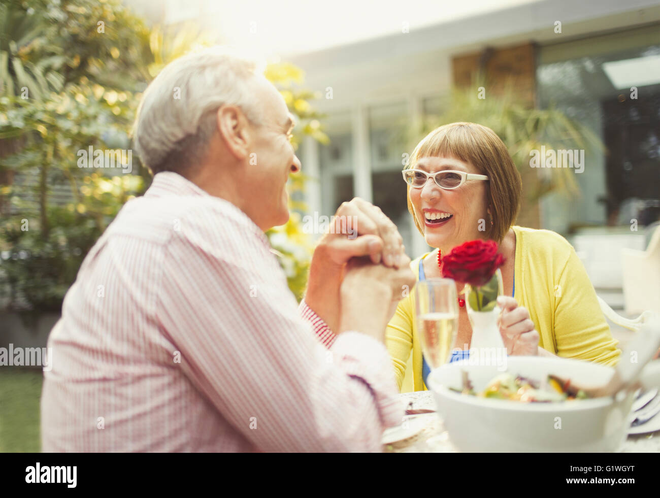 Lächelnd älteres Paar genießen Mittagessen im Garten Stockfoto