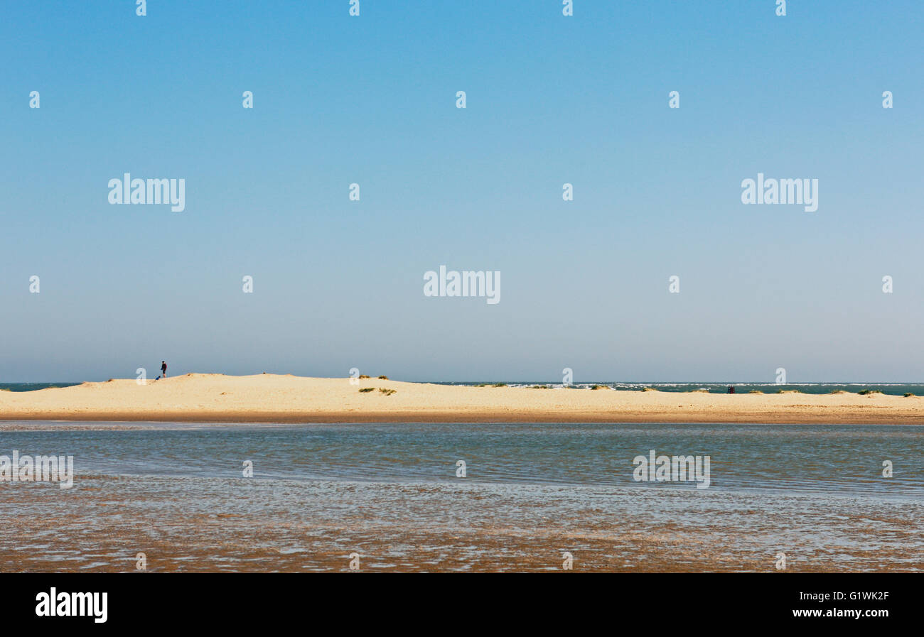 Eine kleine Düne mit einer Figur auf dem Kamm am Strand von Wells-Next-the-Sea, Norfolk, England, Vereinigtes Königreich. Stockfoto