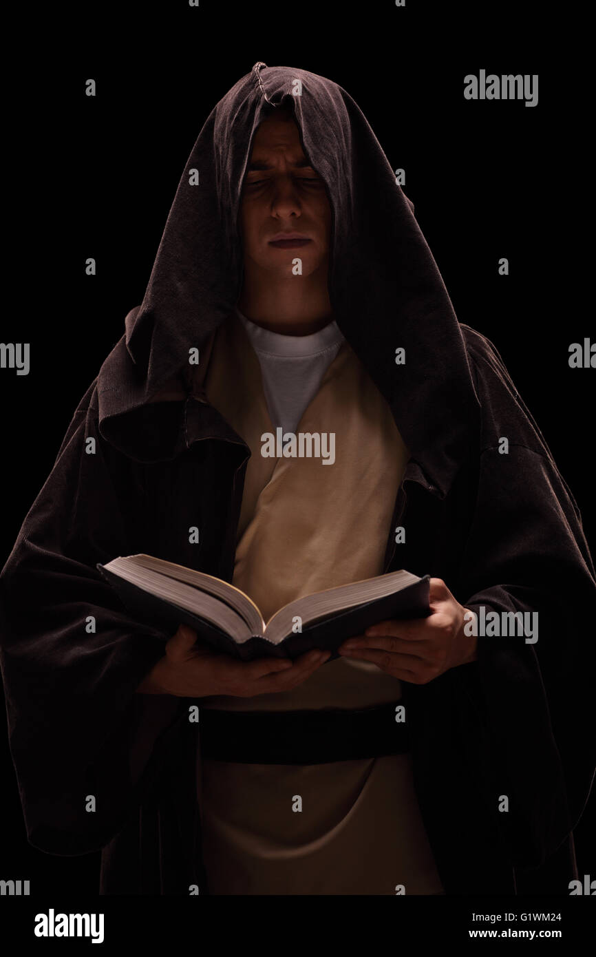 Vertikale Schuss ein junger Mönch, ein Buch lesen auf schwarzem Hintergrund Stockfoto