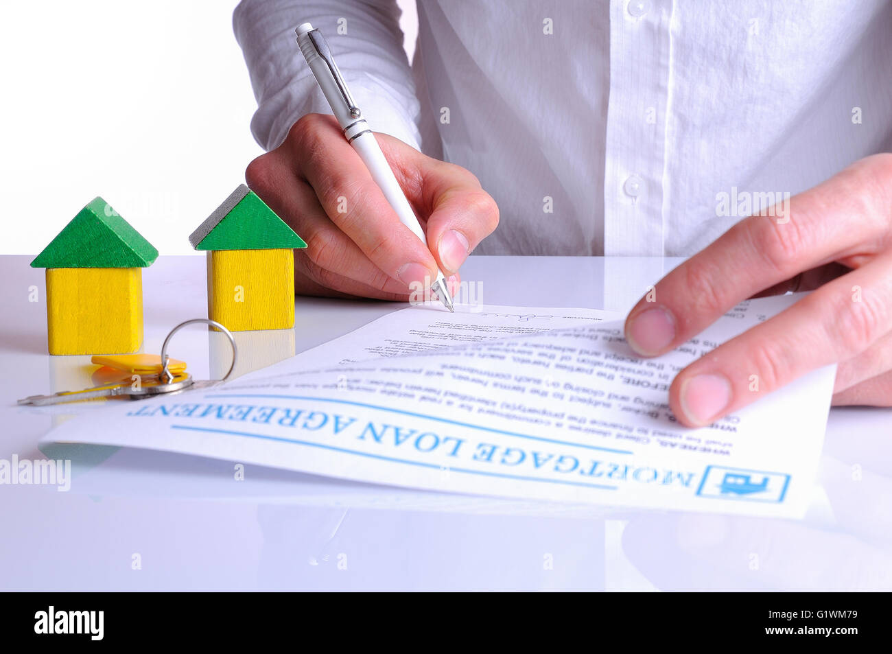 Client, die Unterzeichnung der Hypothekarkredits Darlehen Vereinbarung über den Kauf eines neuen Hauses mit kleinen Holzhäusern Rückansicht Stockfoto