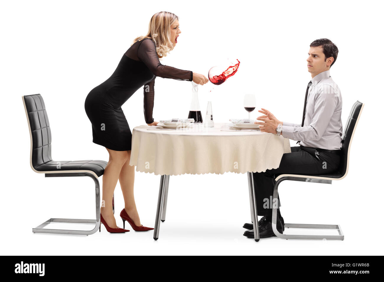 Böse Frau verschütten ihr Getränk auf einen Mann und schrie ihn auf einen Tisch im Restaurant isoliert auf weißem Hintergrund Stockfoto
