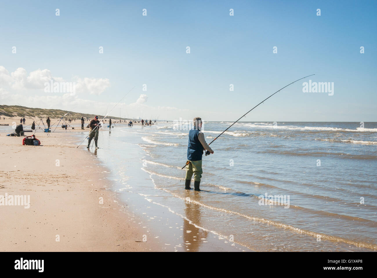 Fischer entlang der Nordseestrand soweit das Auge erreicht, während die Seefischerei Wettbewerbs in Egmond Aan Zee, Niederlande Stockfoto