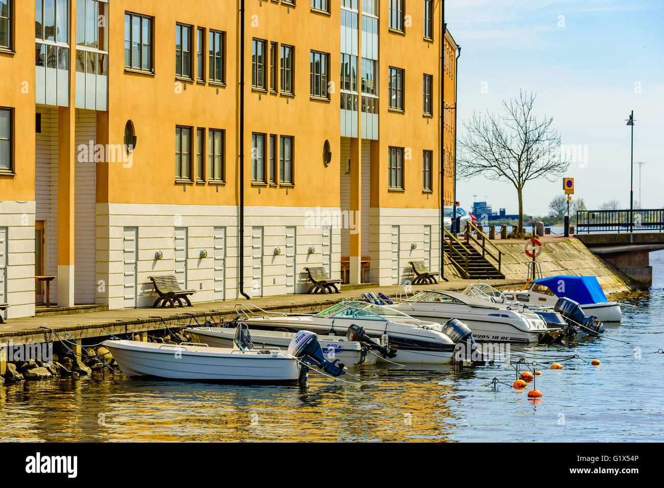 Karlskrona, Schweden - 3. Mai 2016: Coastal Mehrfamilienhaus auf Stumholmen in der Stadt. Gebäude ist gelb. Kleine Sportboote Stockfoto