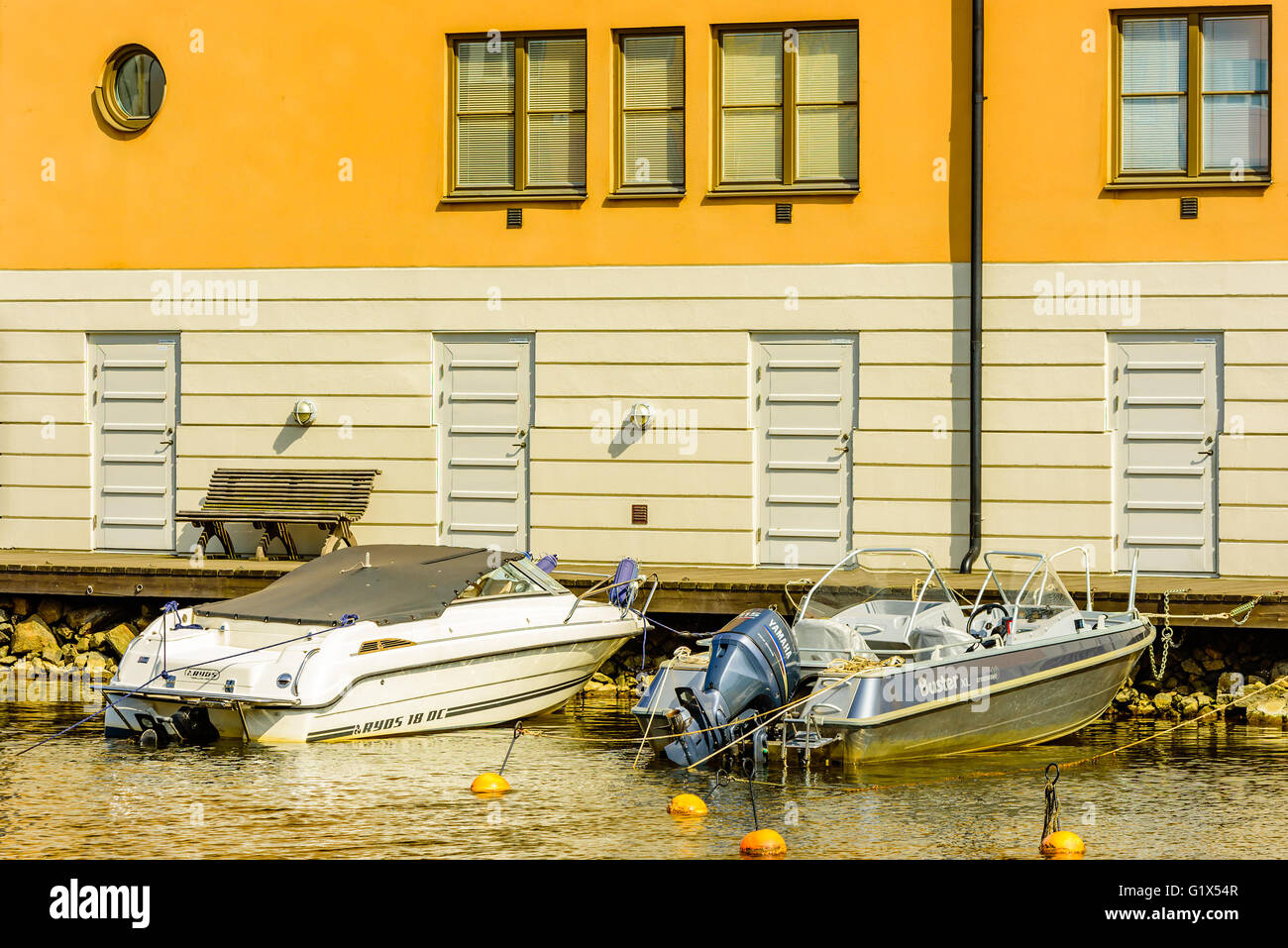 Karlskrona, Schweden - 3. Mai 2016: Coastal Mehrfamilienhaus auf Stumholmen in der Stadt. Gebäude ist gelb. Kleine Sportboote Stockfoto